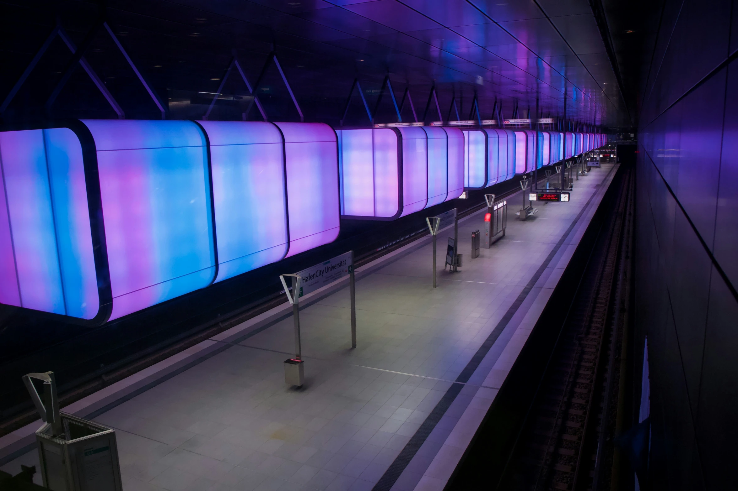 several lights on the side of a wall by some rails