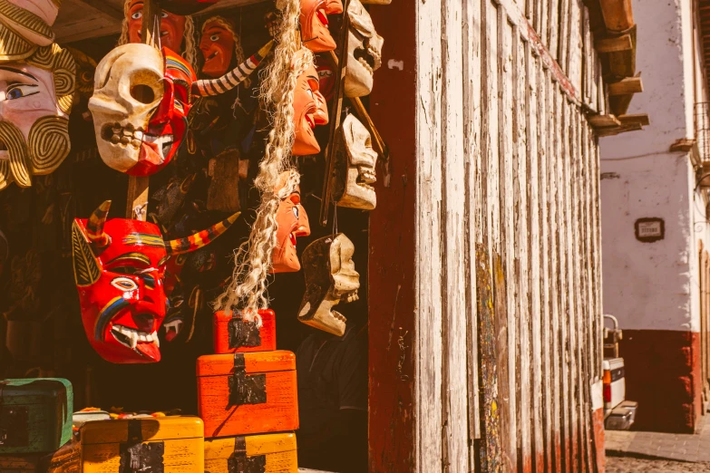 many masks are hung in the open on the market stall