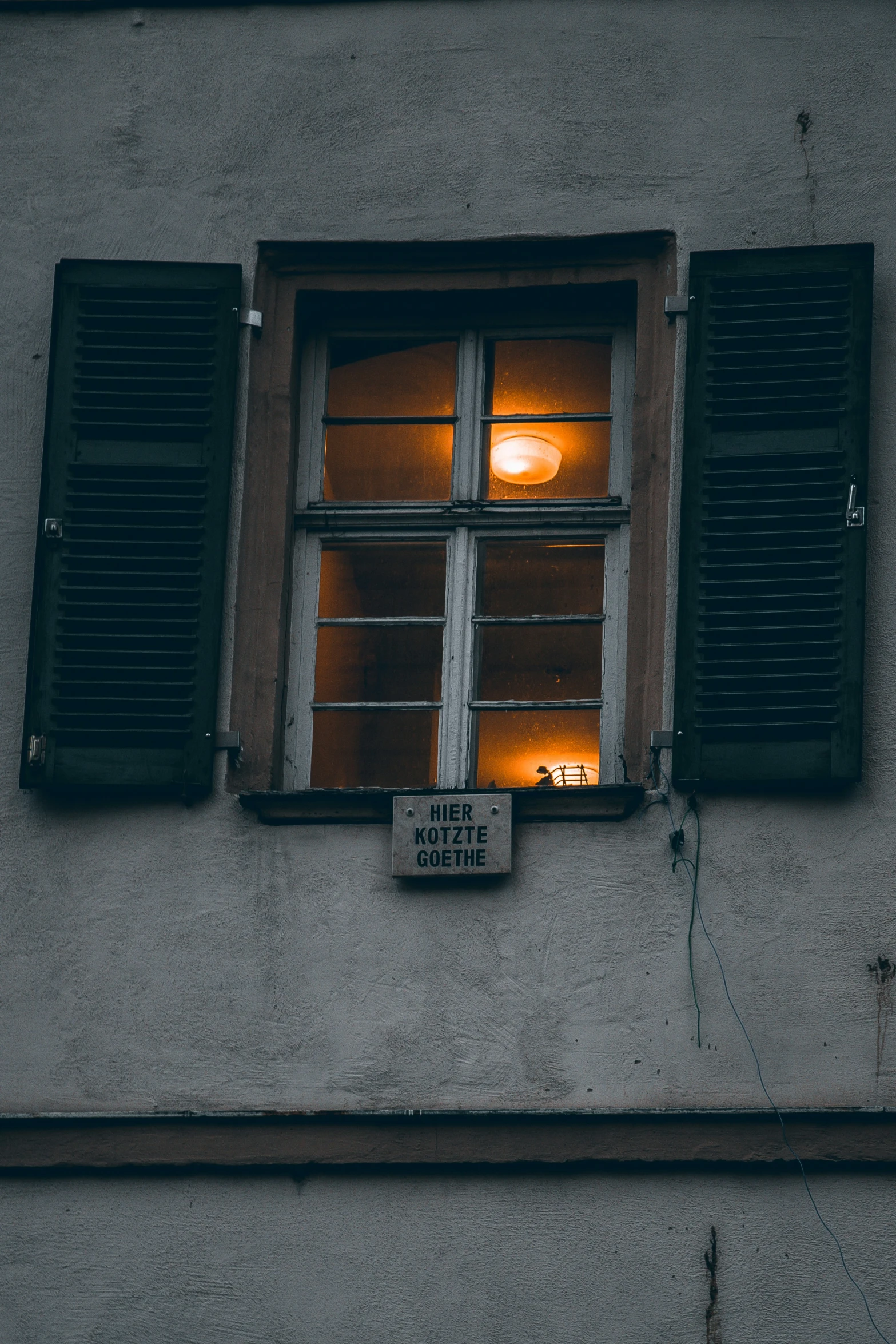 an image of a window lit by candles on the side of a building