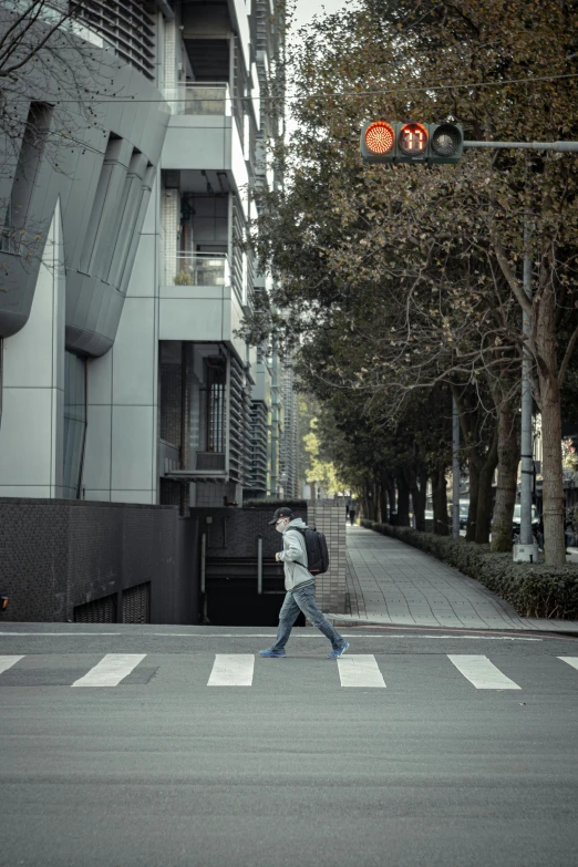 a person crossing the street while holding a backpack