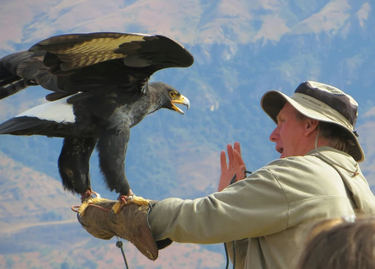 a man in a brown hat holding a bird