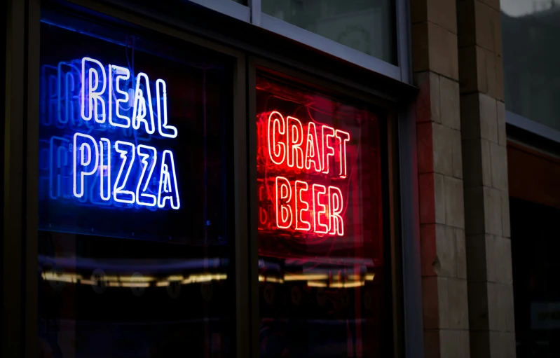 a bright red and blue lighted sign inside of a restaurant window