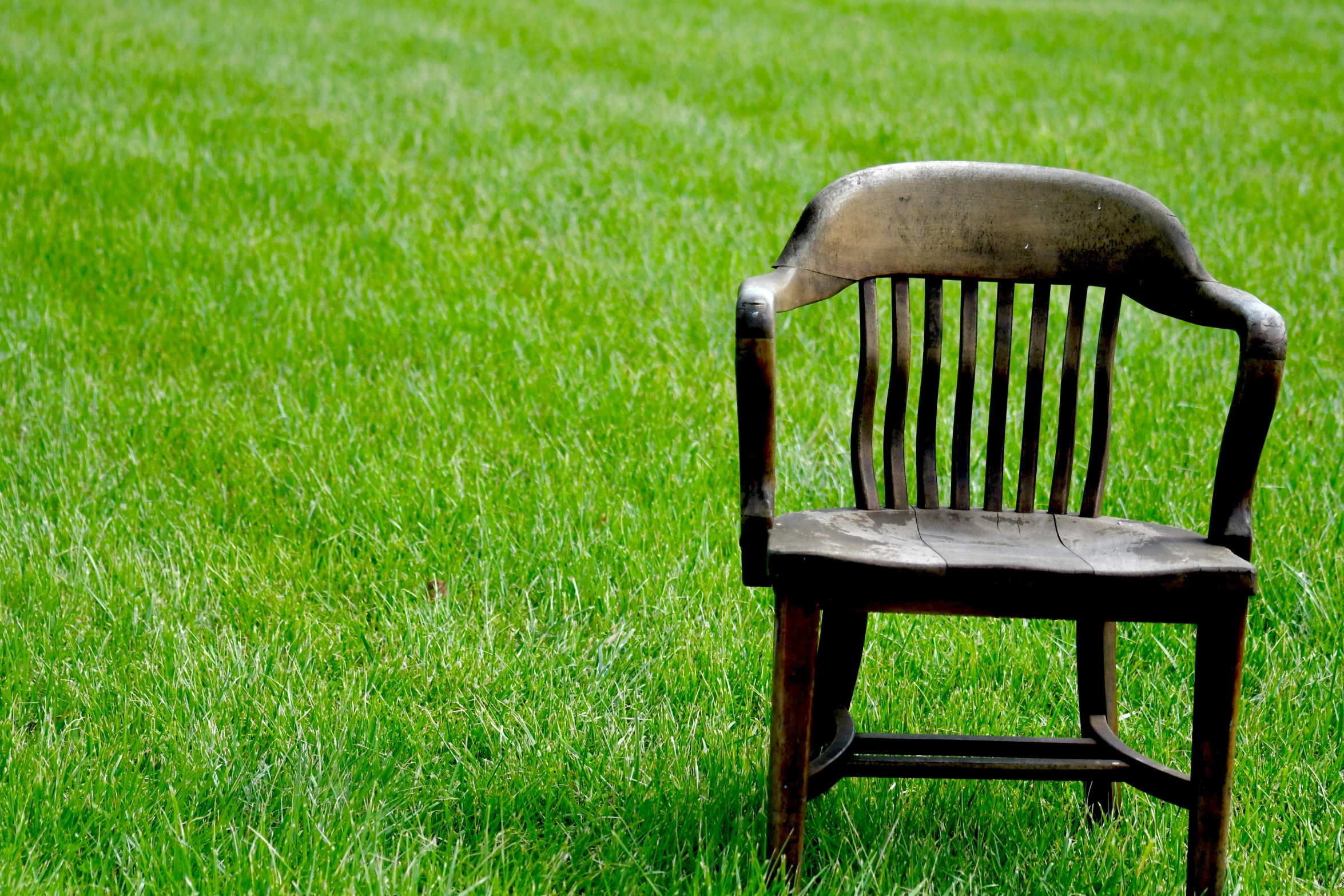 an old chair that is sitting in the grass