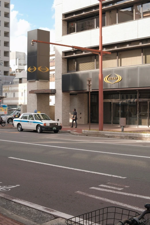 an older police car is parked outside of a shopping center