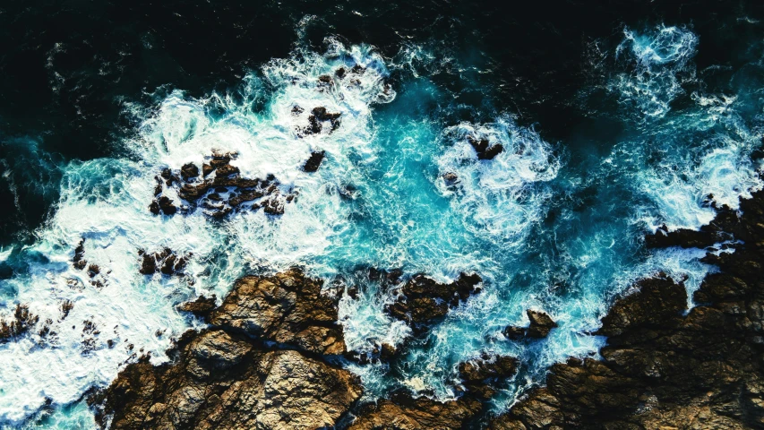 a view from an airplane of some rocky water and rock