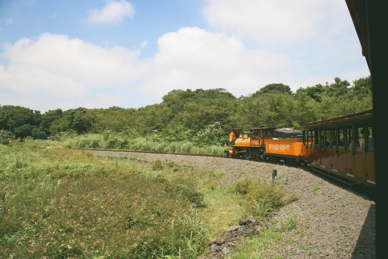 a yellow train traveling through the country side