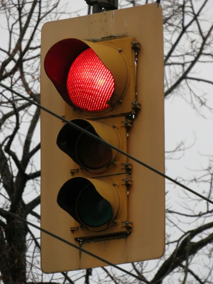 a red traffic light with a yellow traffic signal on a pole