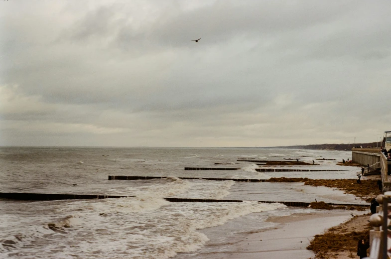 a man standing next to the ocean near jetty