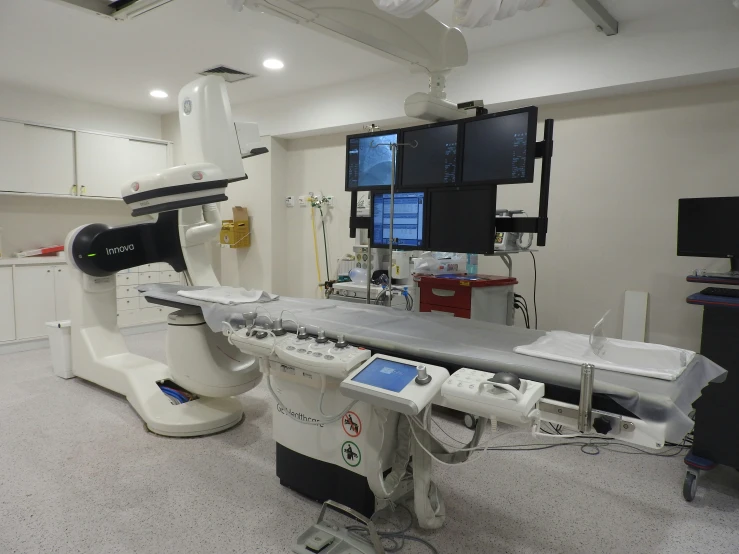 an operating room with medical equipment, including a machine and several monitors