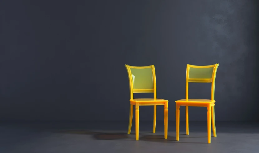 two yellow chairs are facing each other on a grey floor