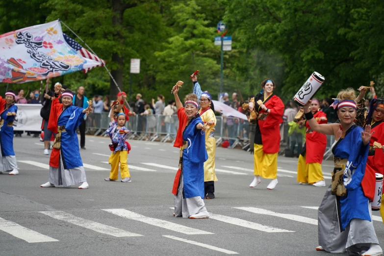 several people are standing in a row and playing on the street