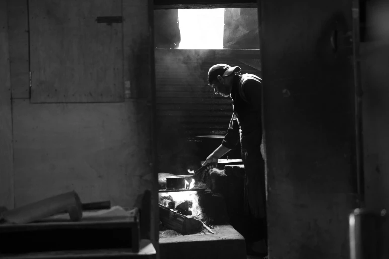 black and white pograph of man standing in front of open doorway