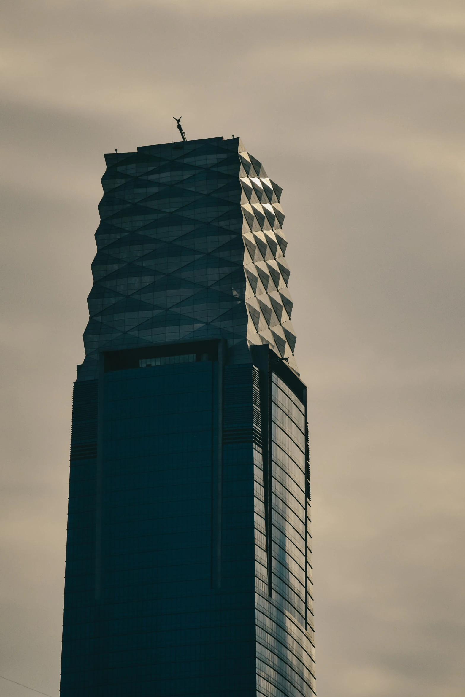 looking up at a tall skyscr under a cloudy sky