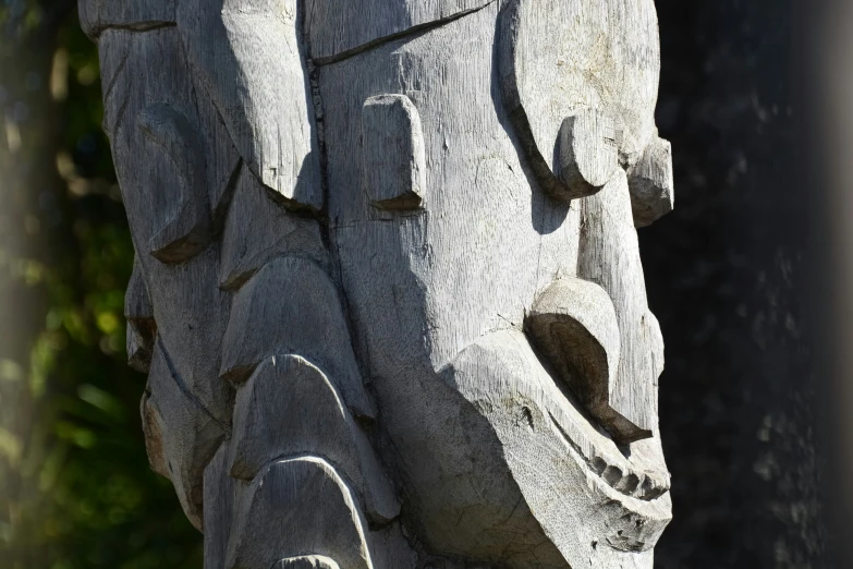 a wooden carved face that looks like a statue