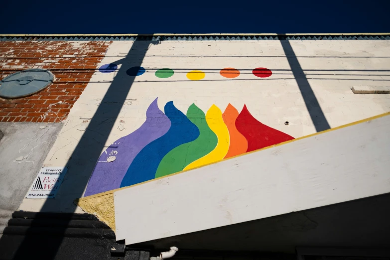 a multi - colored painting is painted on the side of a building