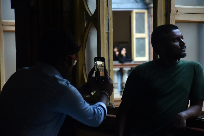 a man taking pictures of himself by the mirror with his cellphone