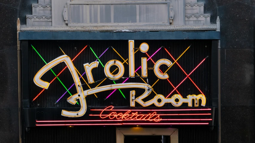 a neon sign above a black store front