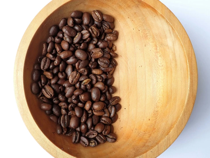 a bowl filled with coffee beans on top of a table