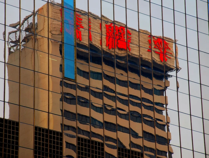 a building reflects the sky as it sits behind some glass