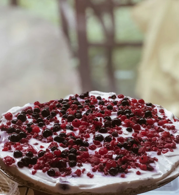 there is a pie topped with cream and cherries on a plate