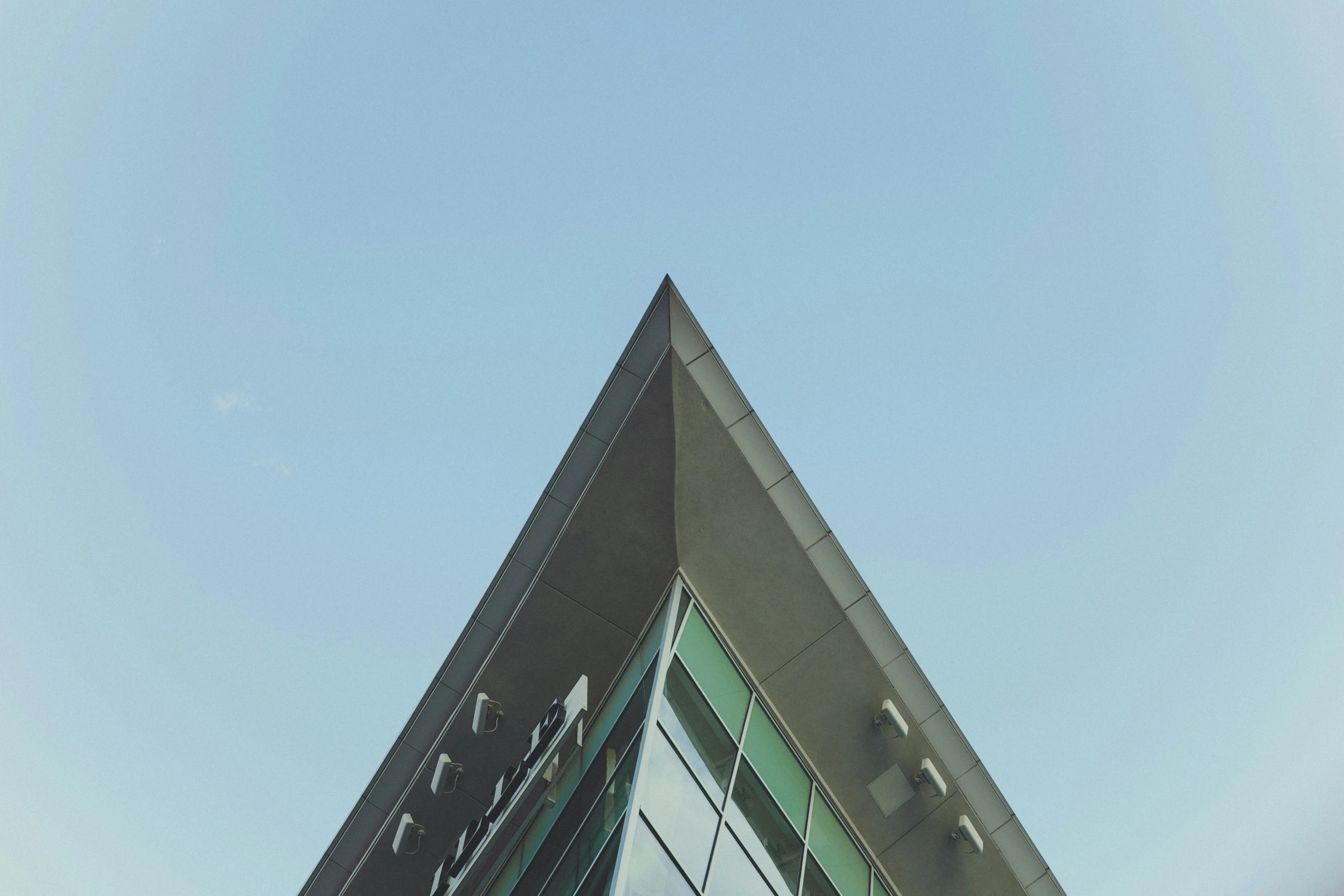 the reflection of a building on its side is seen through the glass