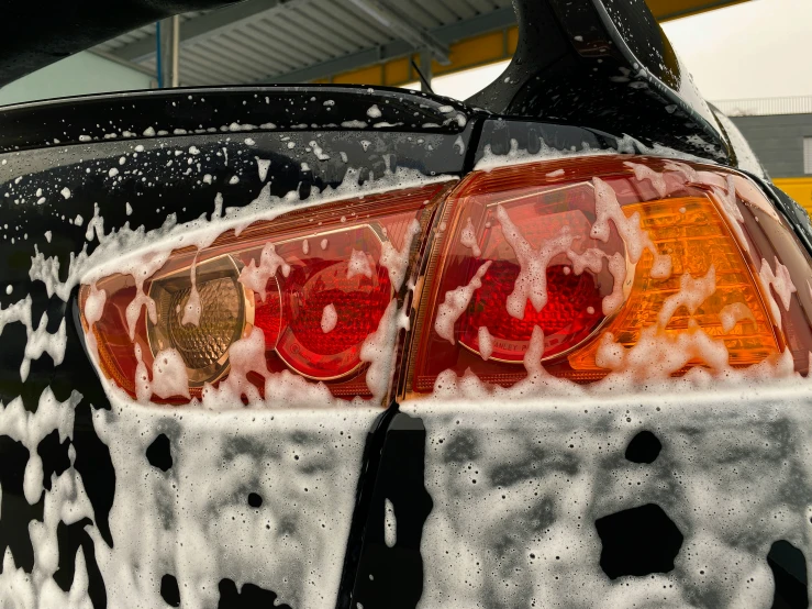 the rear end of a car covered in a lot of rain