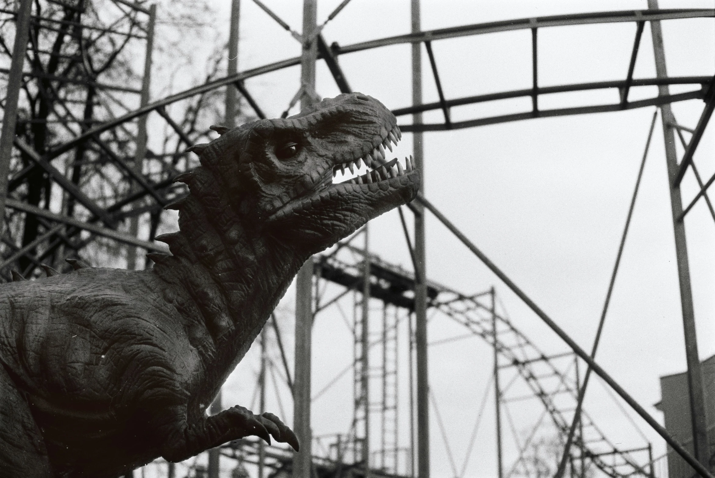 a statue of an alligator next to a roller coaster