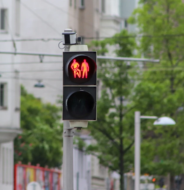 a stop light has two red lights showing pedestrians