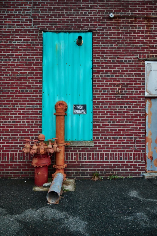 there is a brick building with a blue door and fire hydrant