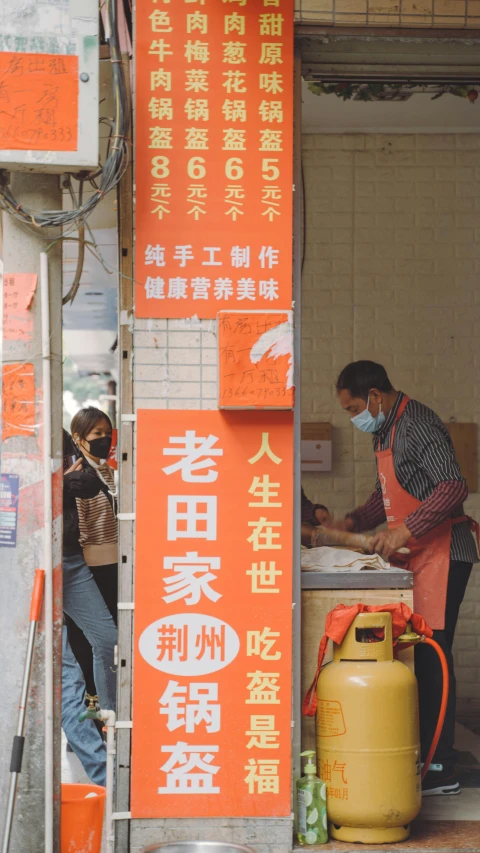 a worker wearing an orange apron stands near a container