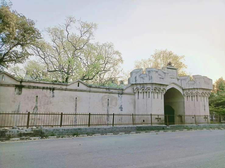 an old brick building with wrought iron fencing