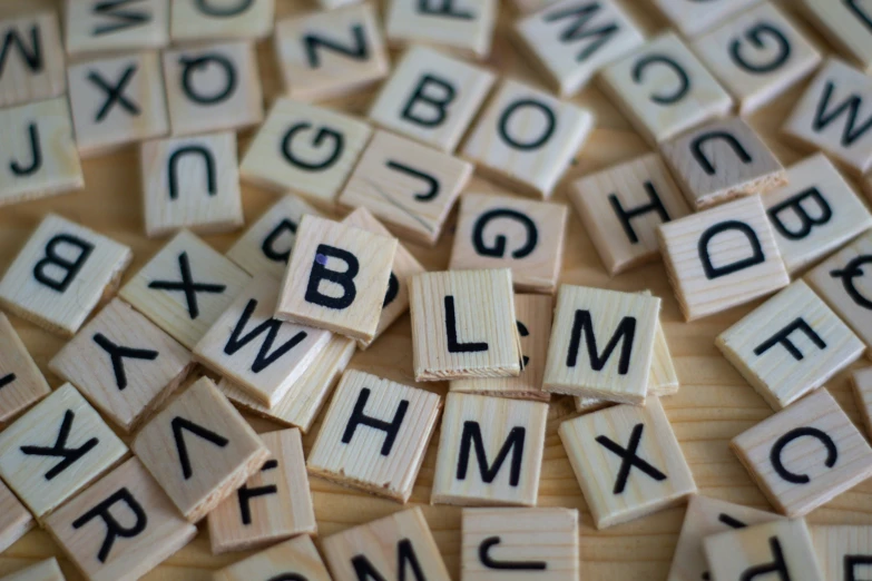a pile of different alphabet tiles with black letters on them