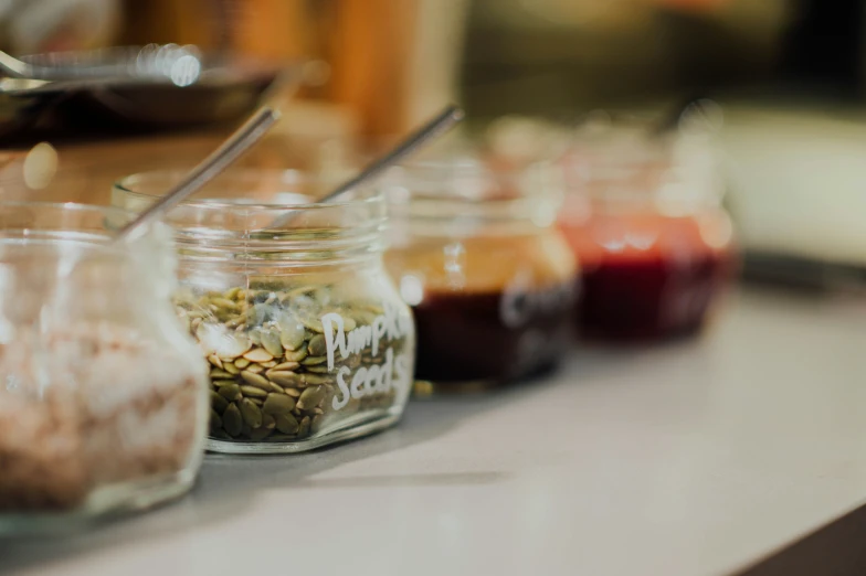 a white counter top topped with small jars filled with food