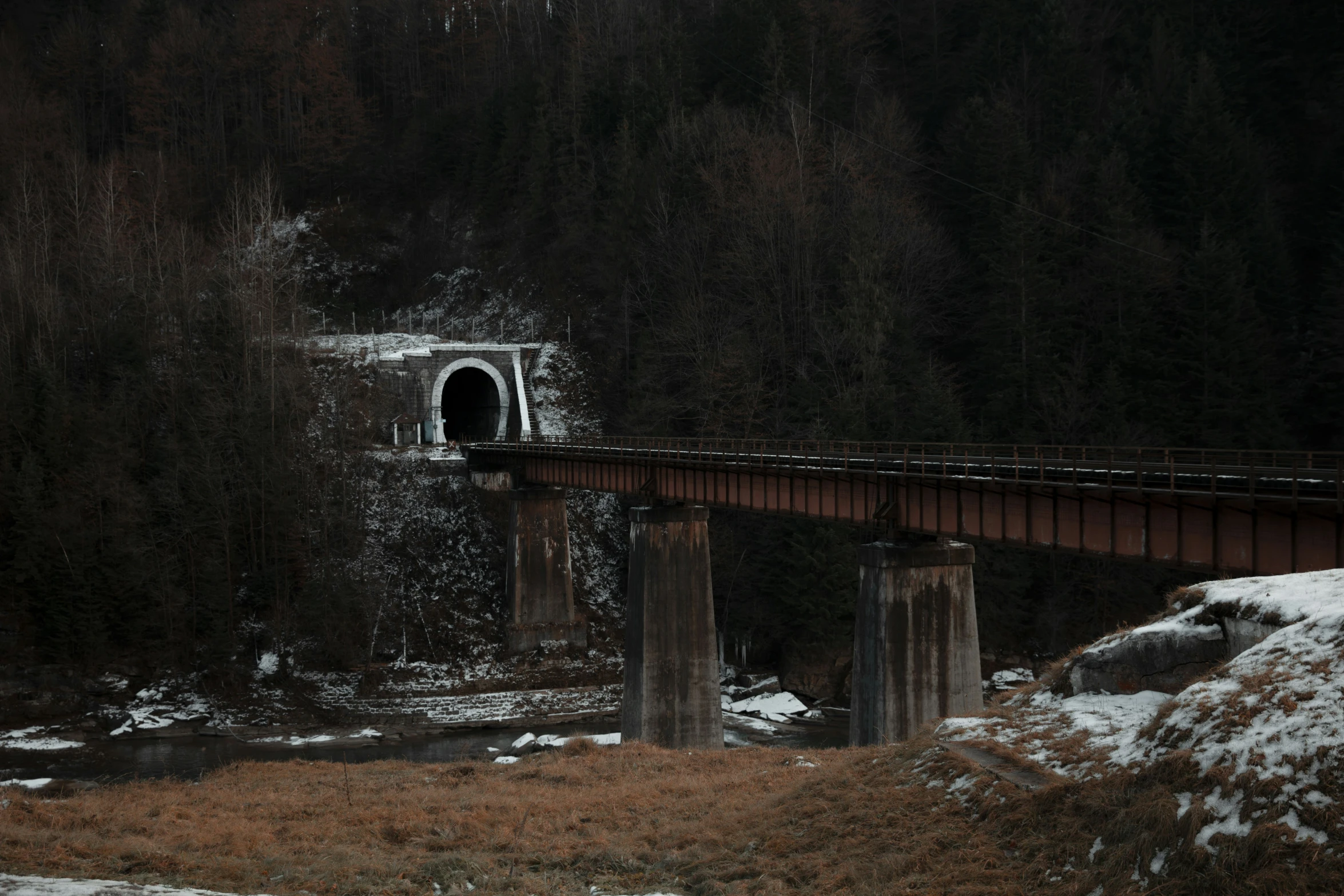 a bridge over a river in the snow