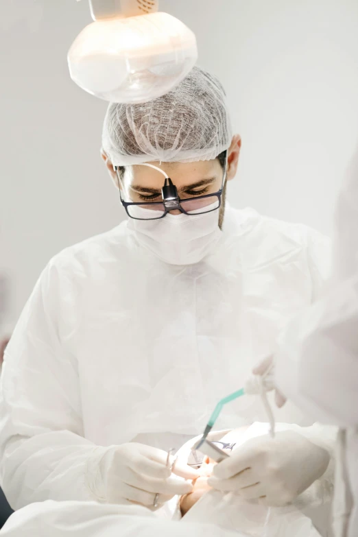 a person wearing glasses and holding a pair of scissors