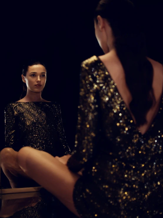 two women standing in front of a black backdrop