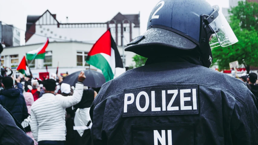 an armed police officer stands at attention during a protest