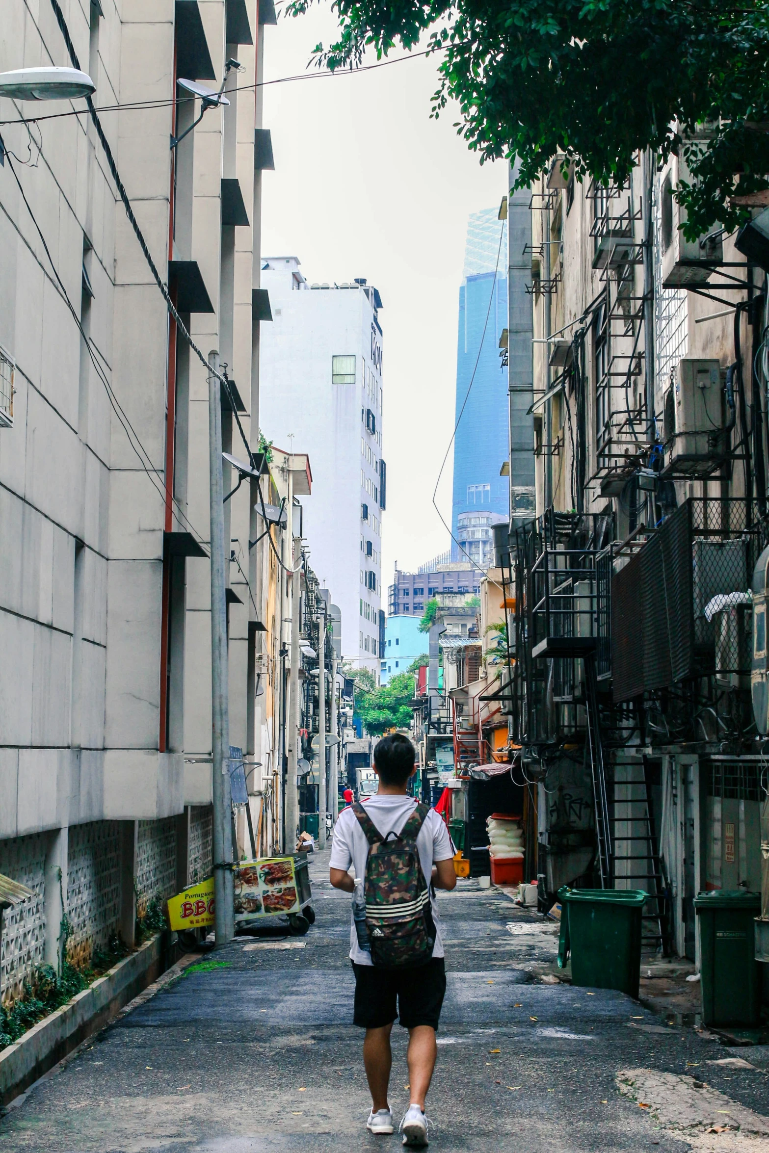 a man walking down a small alley way in a city