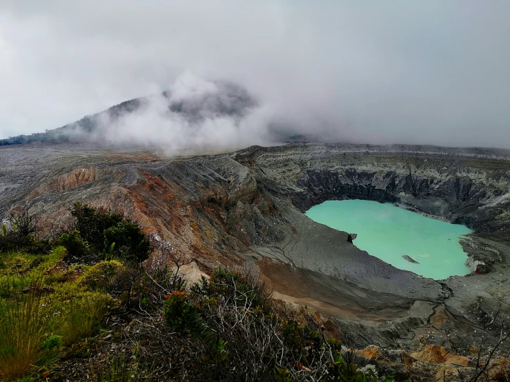 a blue crater in the middle of a mountain