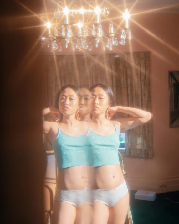 three women in underwear standing in front of a mirror