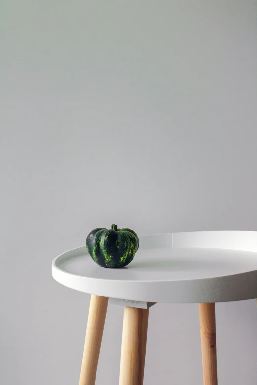 a green object is sitting on the side of a table