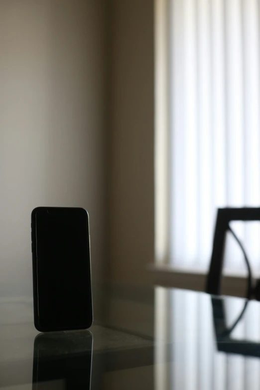 a table and a chair with a small black object on it