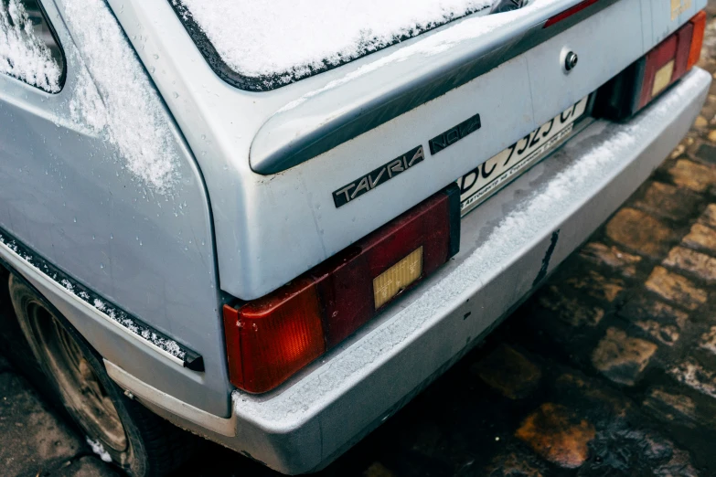 an old car that is partially covered by snow