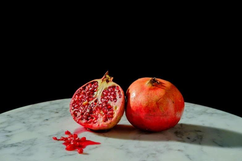 a pomegranate sitting next to a piece of fruit