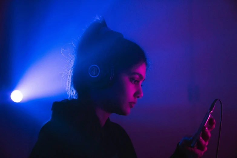 a woman wearing headphones and playing on her smartphone