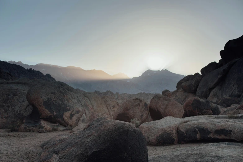 rocks covered in sand with mountains in the background