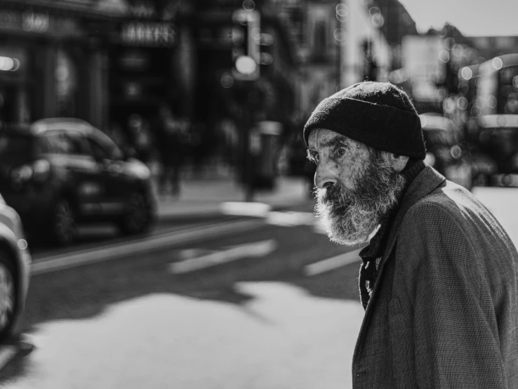 a man with a hat and a beard walks down the street