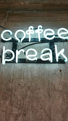 a sign that says coffee break on a wall