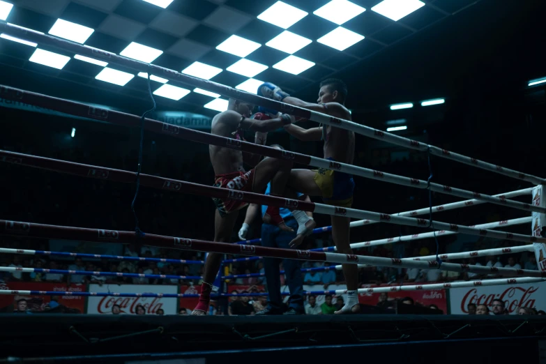 two men are in an arena boxing under the lights