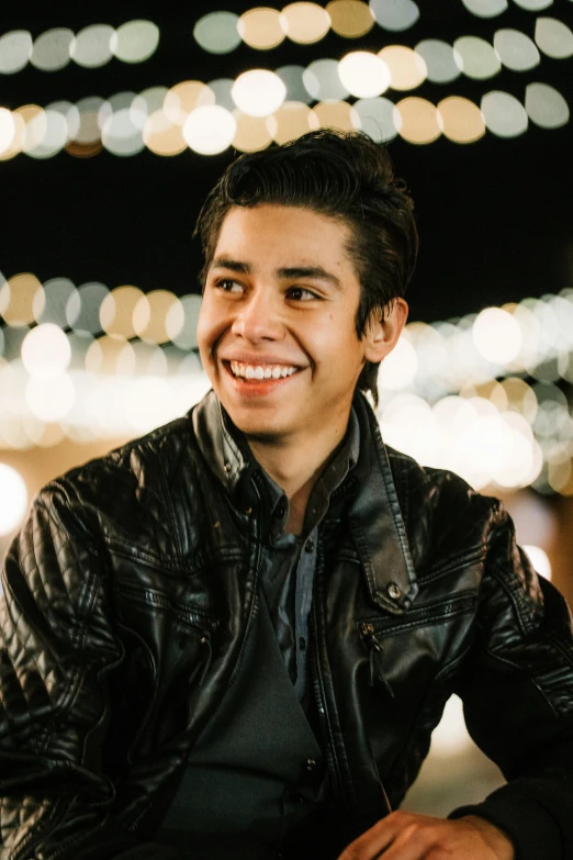 a man sitting down smiling at the camera